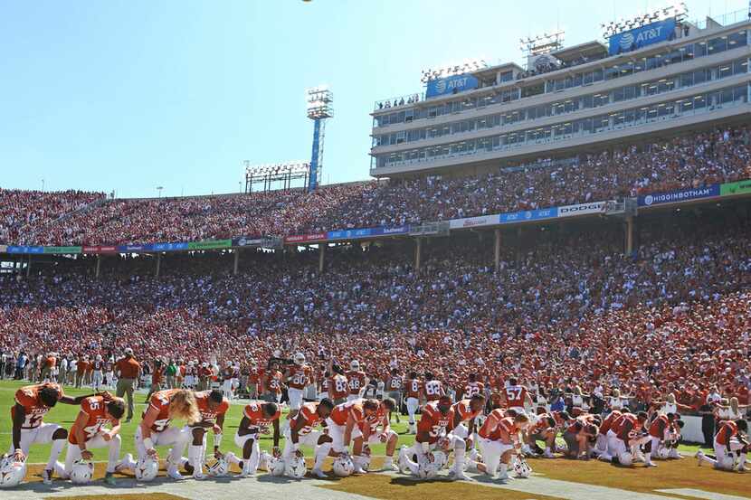Longhorn players kneel in the end zone to pray before the Oklahoma University Sooners vs....