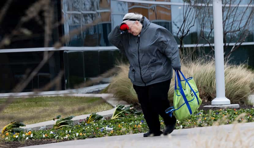 A woman fought the sharp winds on Thursday, Dec. 22, 2022, at The Epic in Grand Prairie. An...