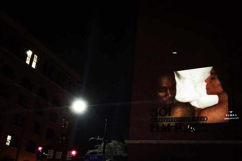 Kanye West and Kim Kardashian West are shown in "Famous" as the music video is projected on...