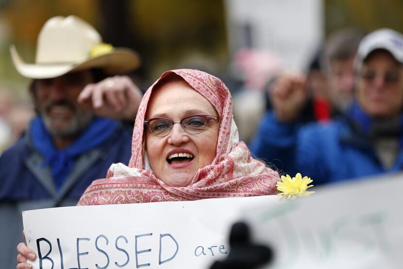 
Sally-Page Stuck of Dallas sings during a peaceful rally last year to counter a gun-toting...