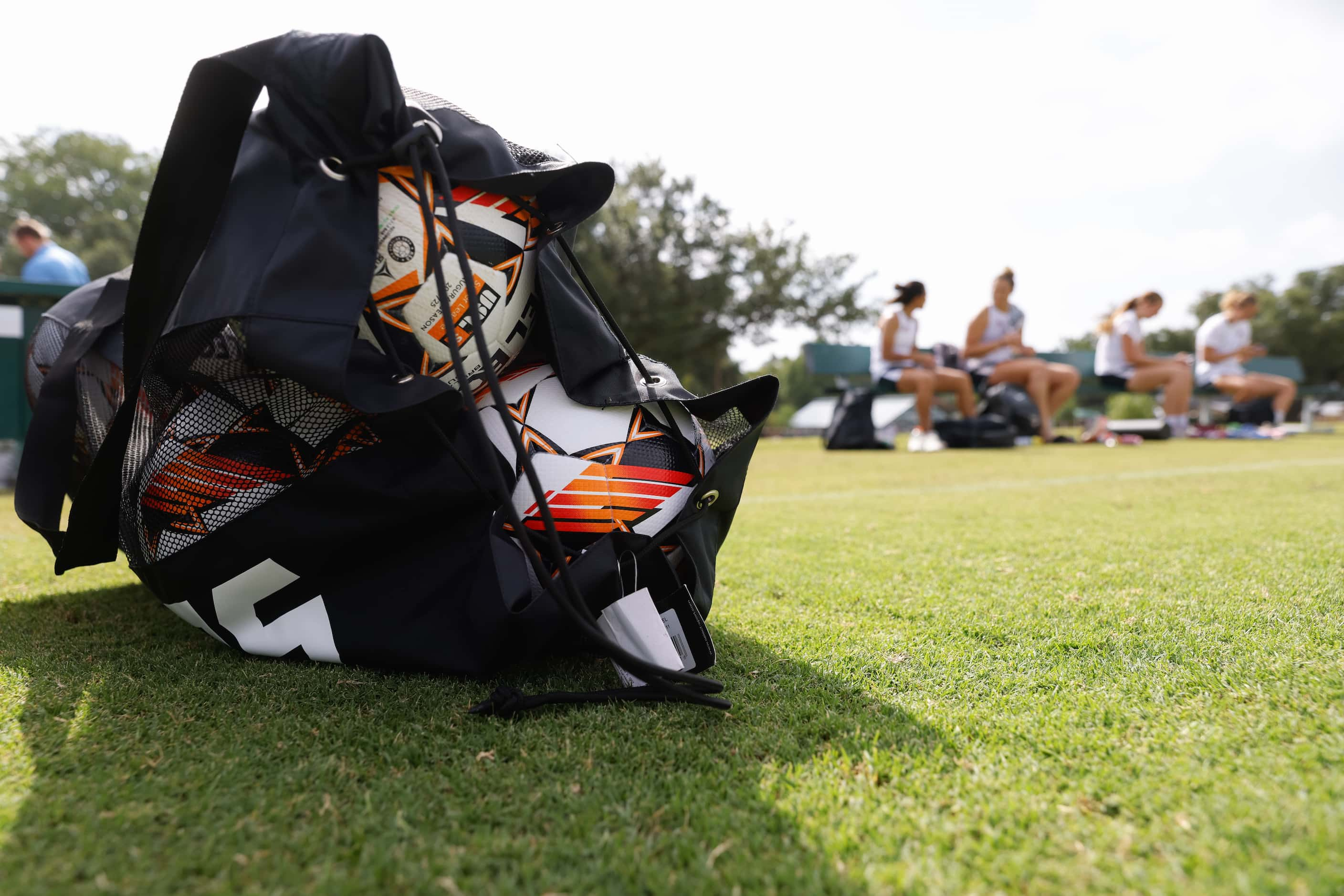 Dallas Trinity FC player rest on a bench following the brand new women's professional soccer...