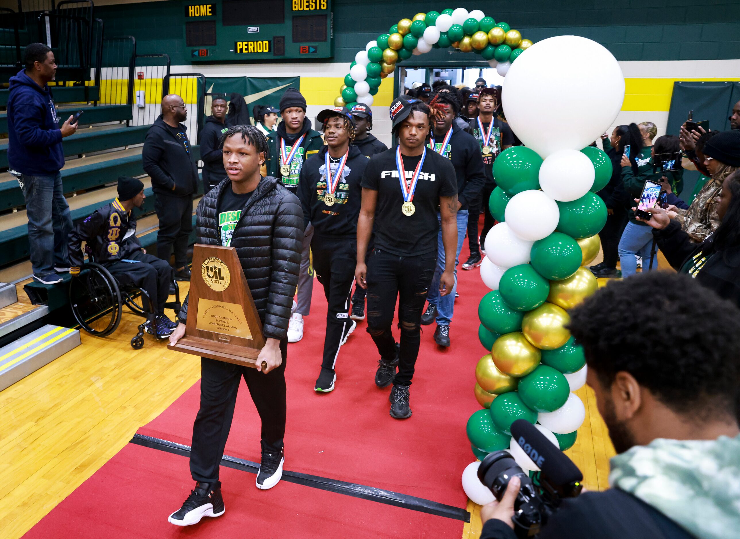 DeSoto High School’s football team walks into the Chris Dyer Gymnasium, Saturday, Jan. 21,...