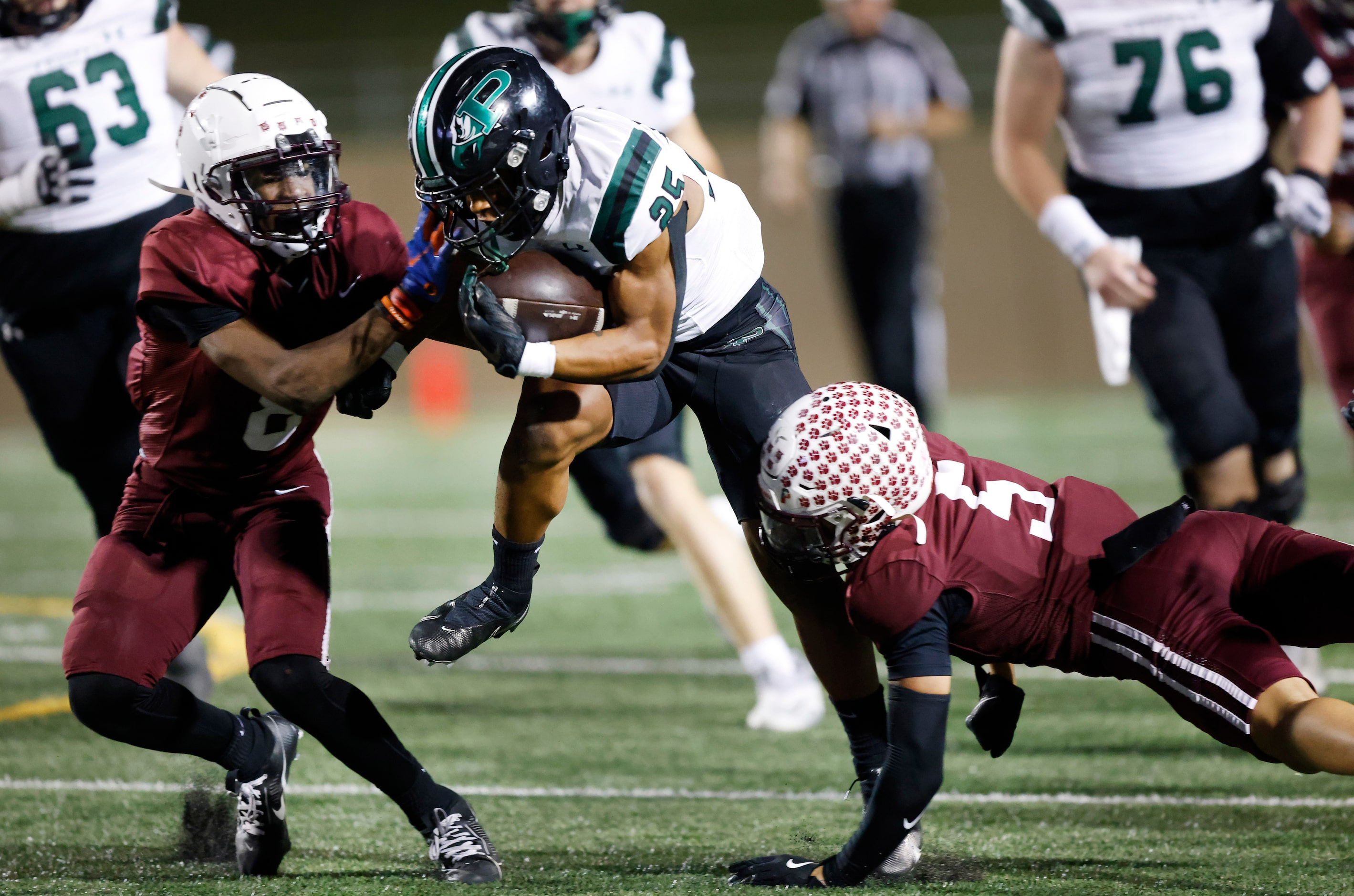 Prosper High running back Jacob Martinez (25) is tackled by Plano High’s Bradley Brown...