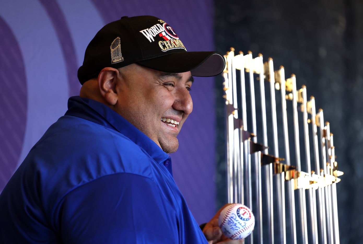 Texas Rangers fan Rob Mendiola beams as he poses for a souvenir photo next to the Rangers'...