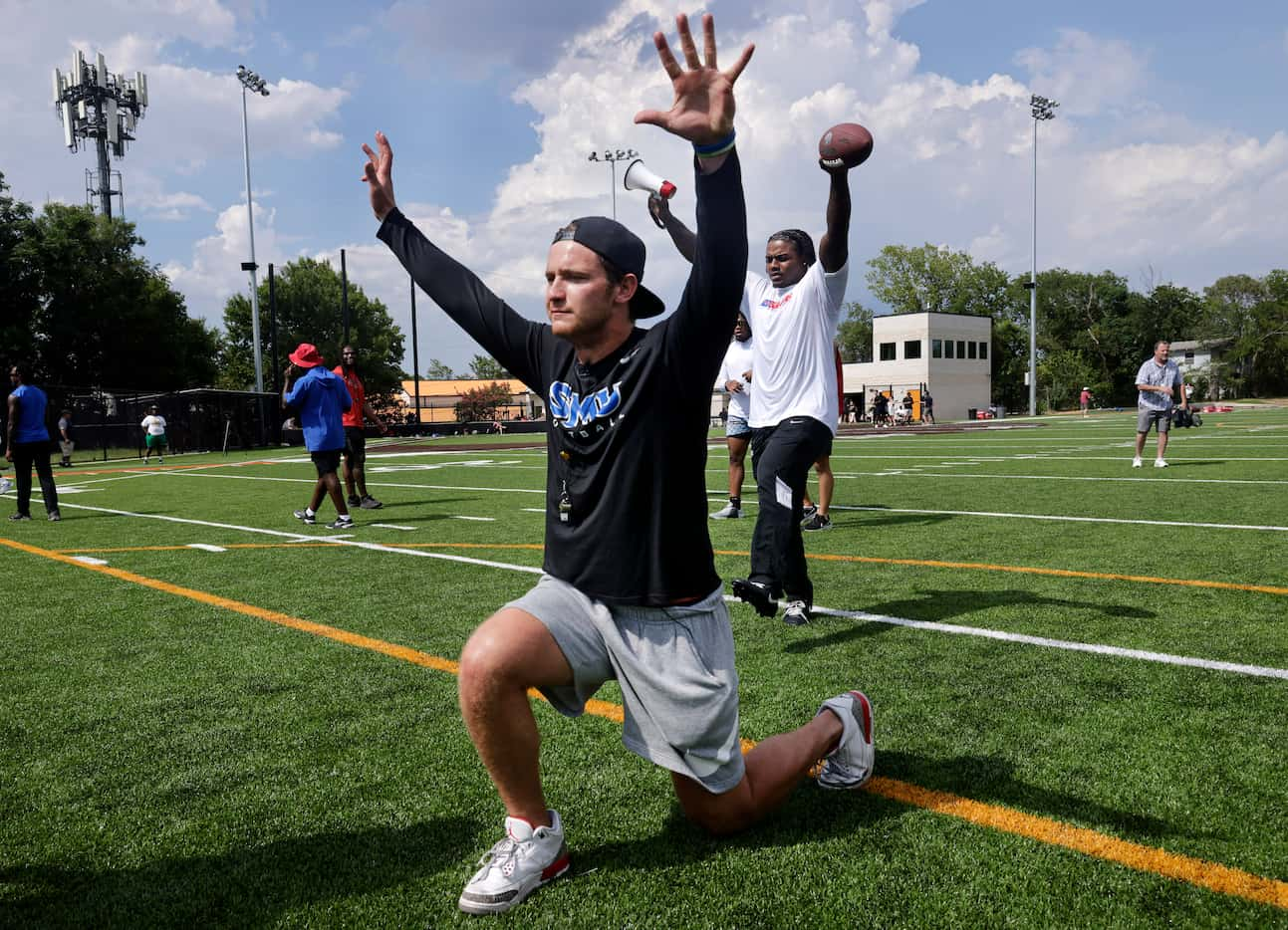 SMU quarterback Preston Stone shows kids how to stretch as they participated in the United...