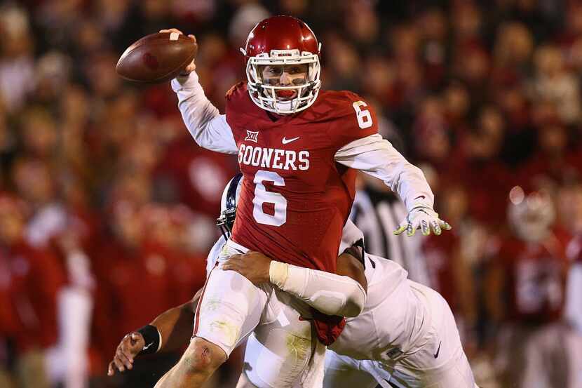 Baker Mayfield #6 of the Oklahoma Sooners throws the ball against Aaron Curry #95 of the TCU...
