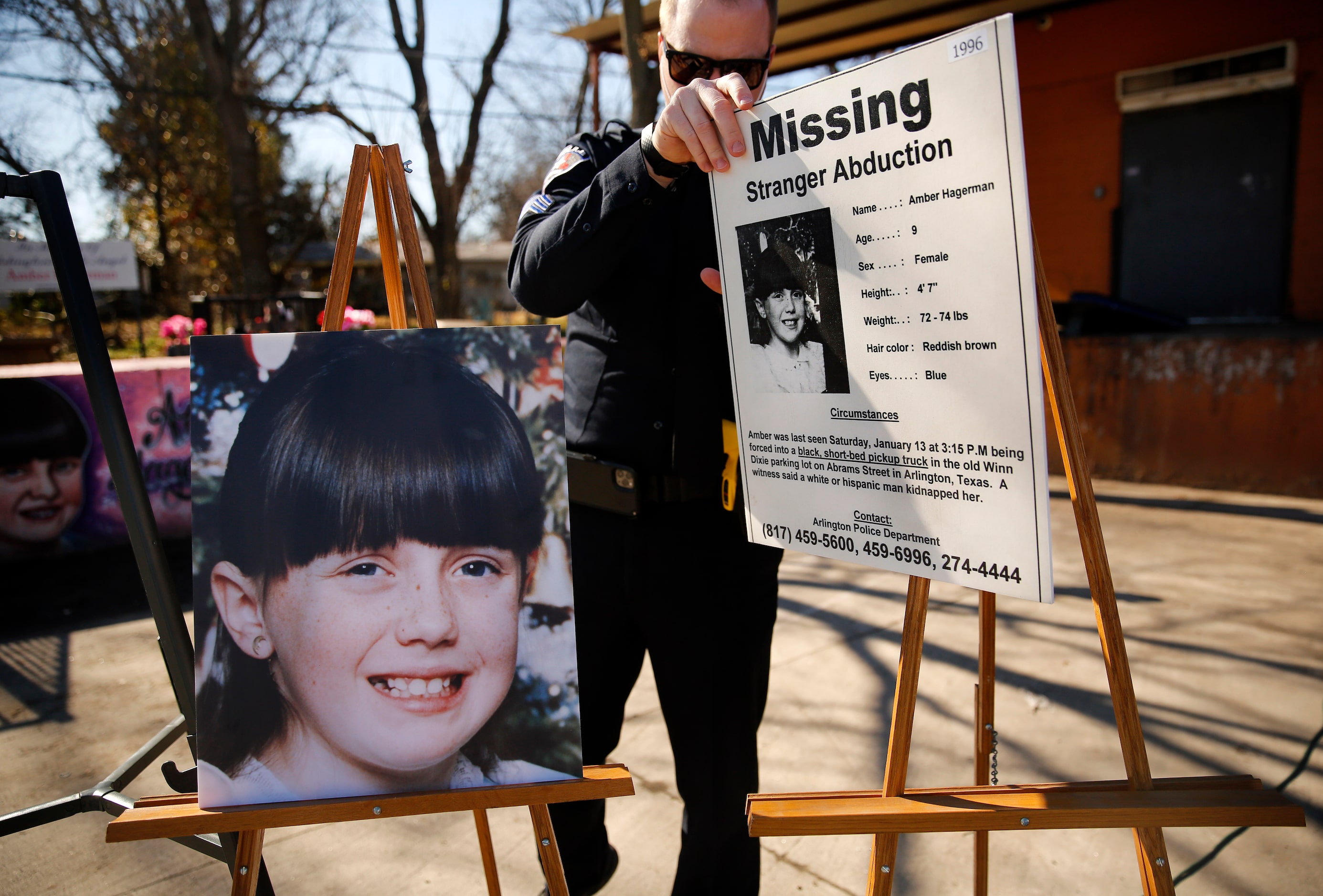 Arlington Police Sgt. Michael Chitty removes a the original 'Missing' alert and a photo of...