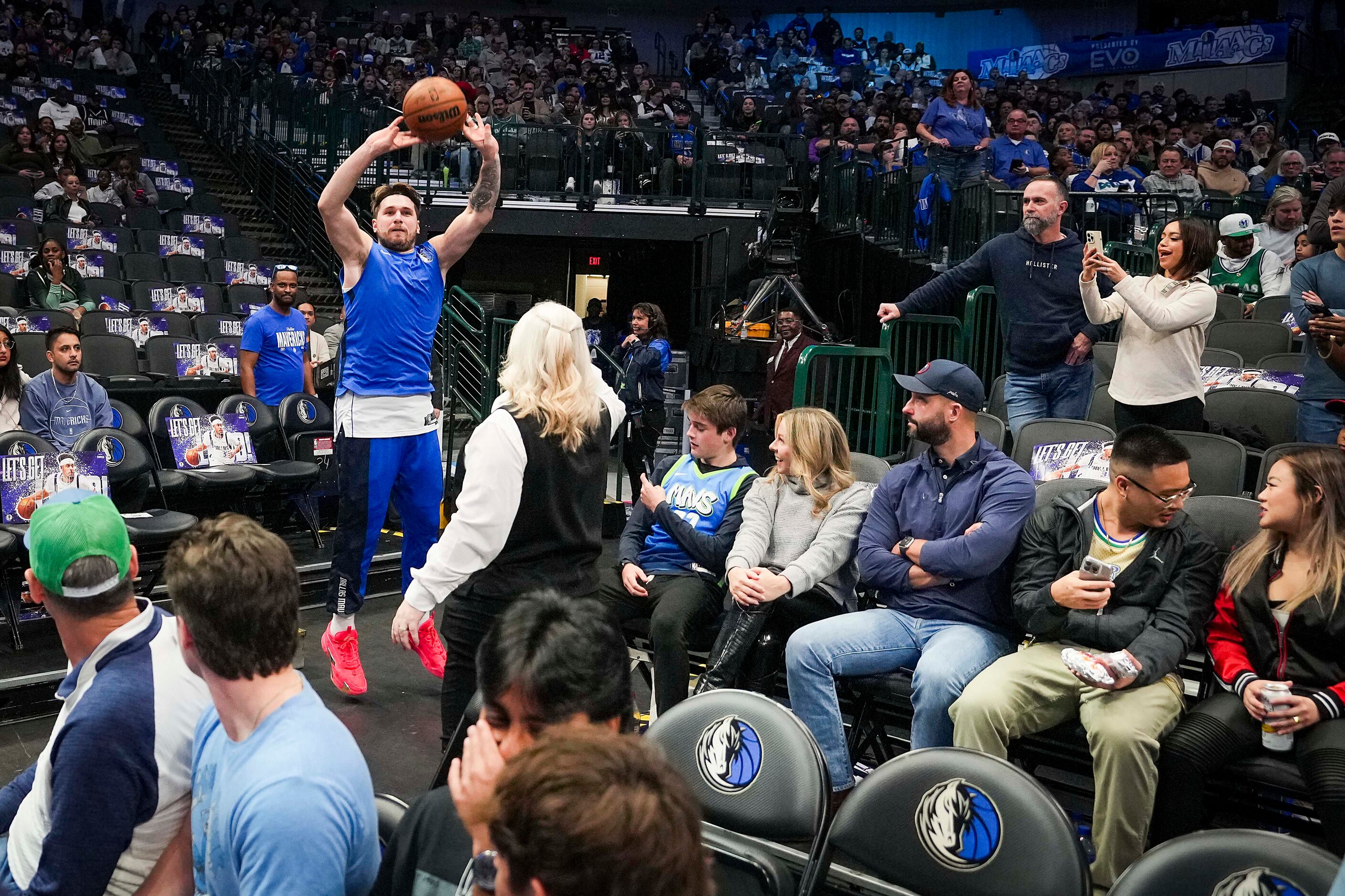 Dallas Mavericks guard Luka Doncic takes a shot from the crowd while warming up before an...