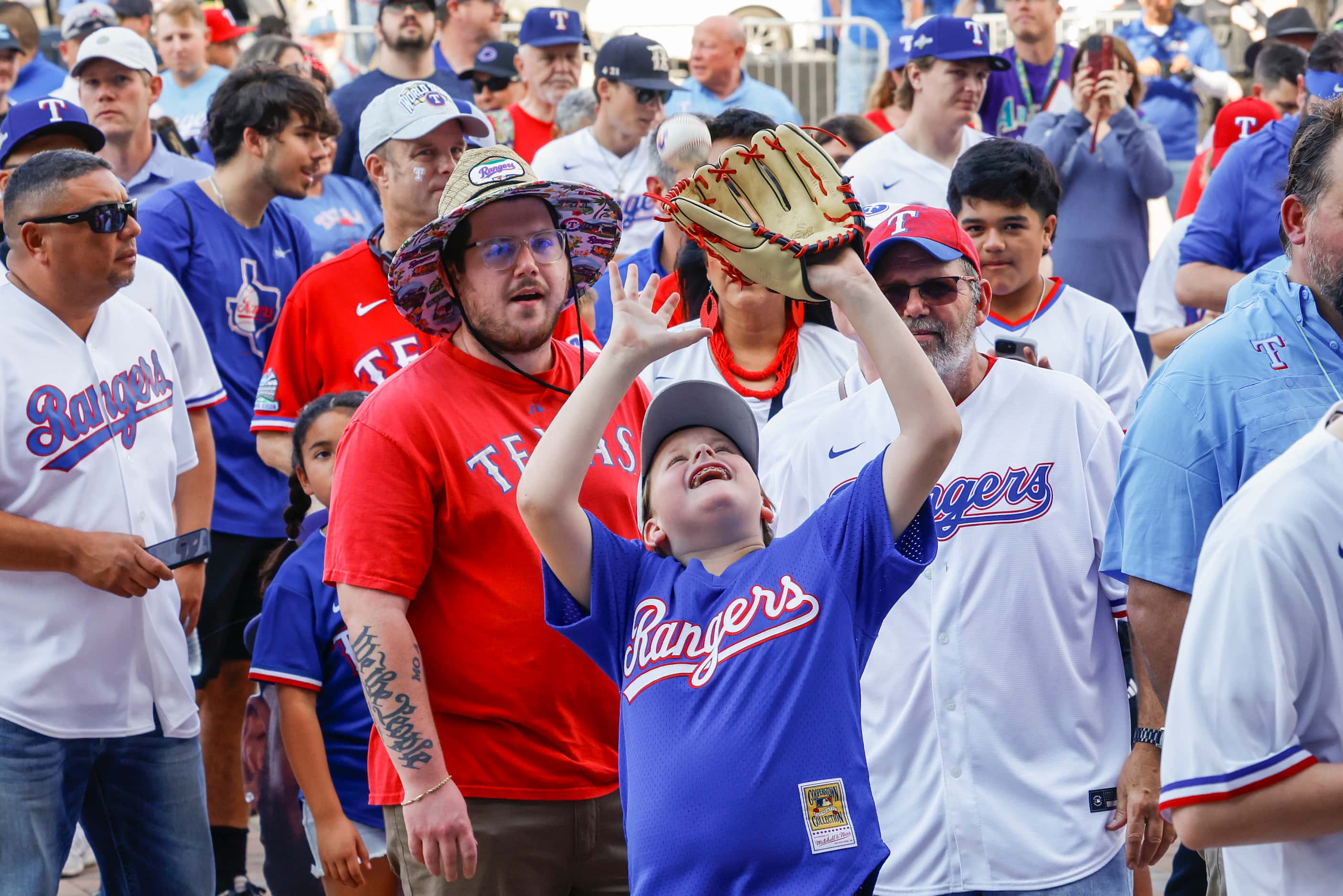A young fan tosses a baseball while waiting outside of Globe Life Field prior to Game 1 of...