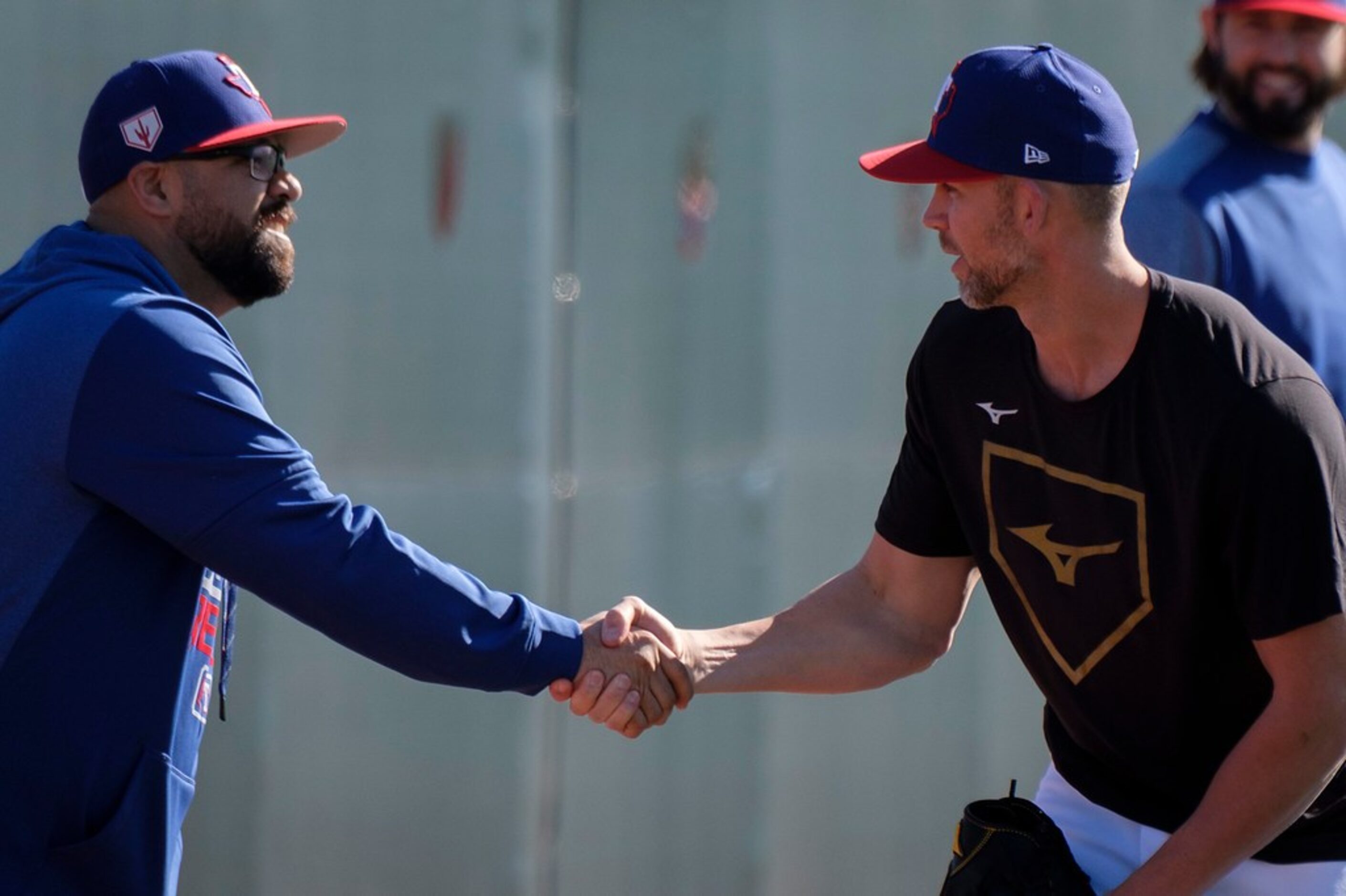 Texas Rangers pitcher Mike Minor (right) shakes hands with the team's new bullpen coach...