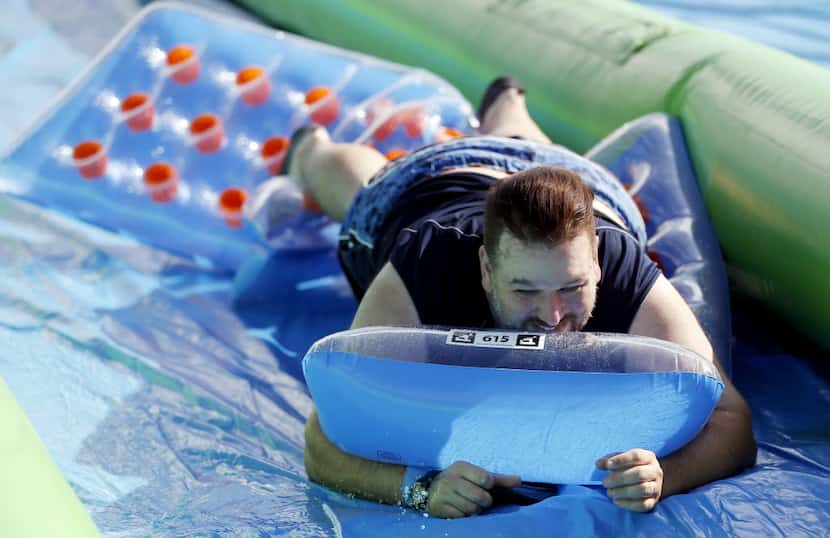 Andy Anders slides down a 1,000 foot water slide during the Slide the City event in the 3400...