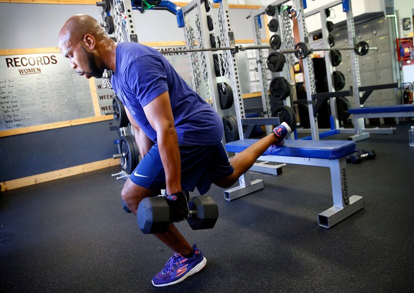 Donovan Lewis uses dumbbells while doing Bulgarian split squats.