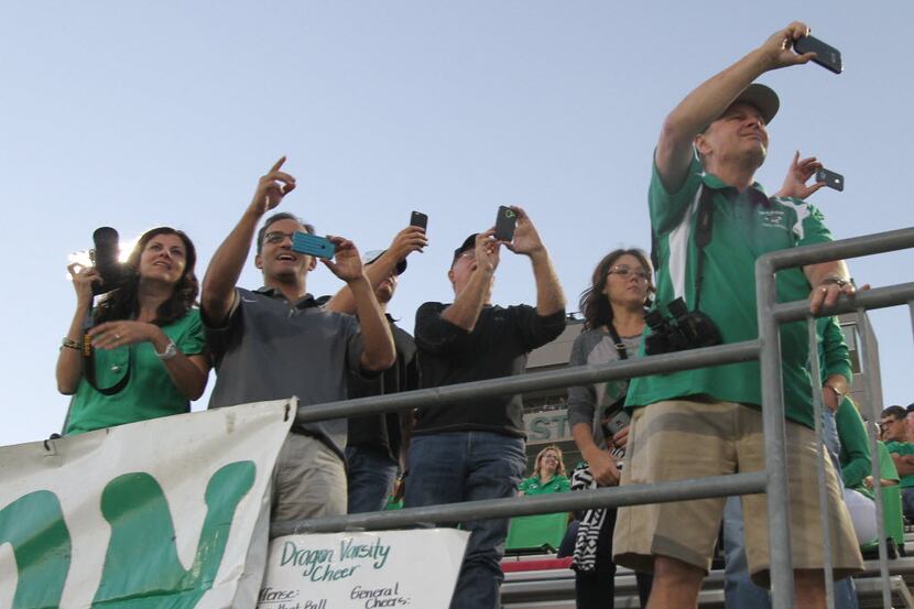 Southlake Carroll fans scramble to capture photos of friends and family members on the field...