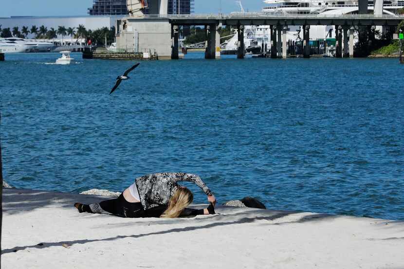 In this March 20 photo, a woman works out near Bayfront Park amid the coronavirus outbreak...