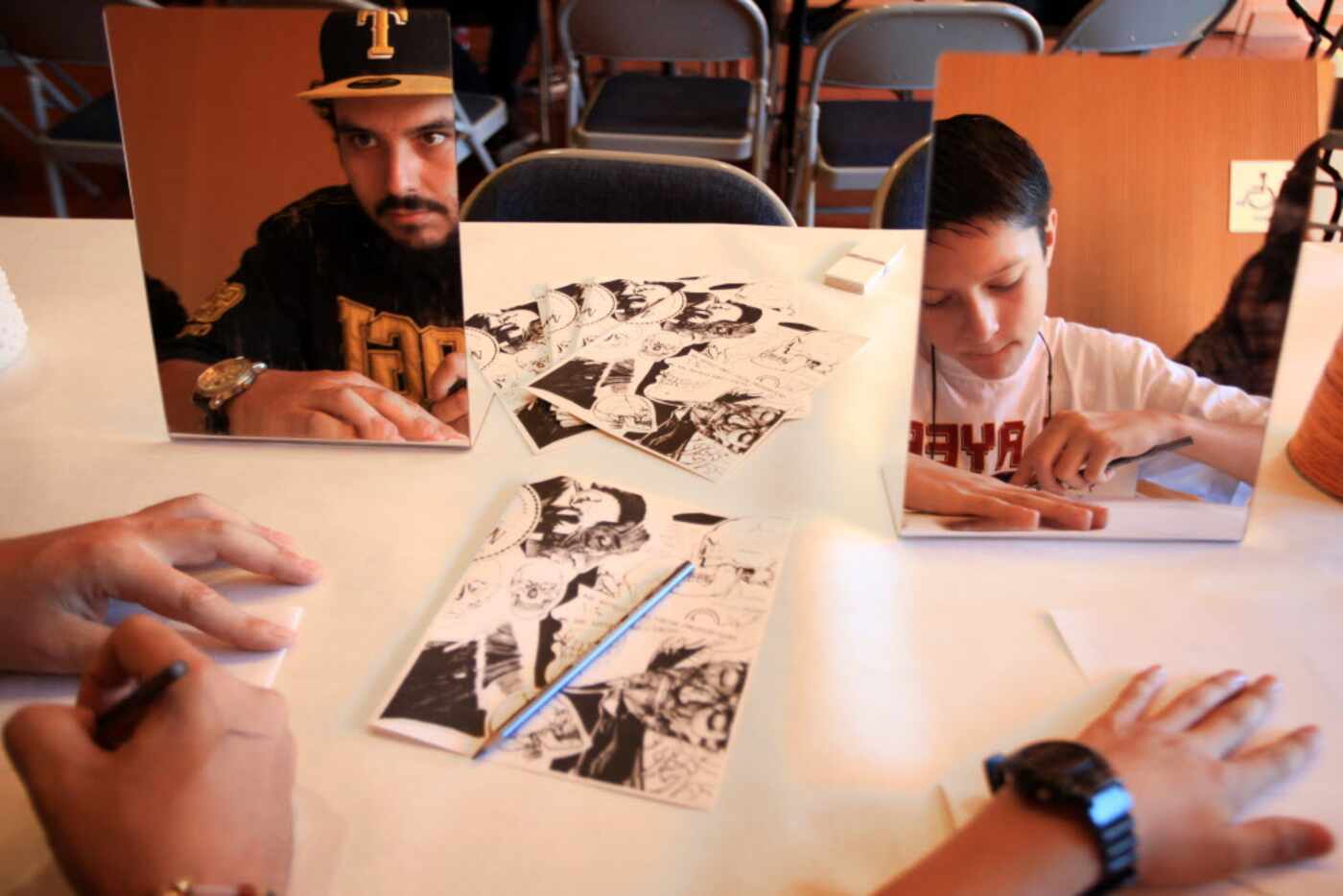 Ramiro Santos, left, and Armando Zuniga, 12, worked on their self portraits, during an...