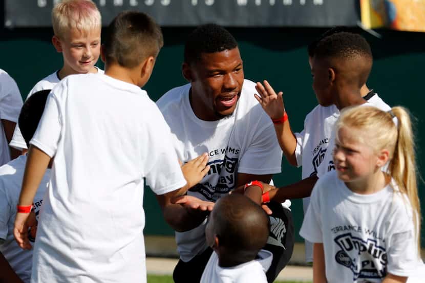 Dallas Cowboys wide receiver Terrance Williams high fives kids at the Kroger Unplug and Play...
