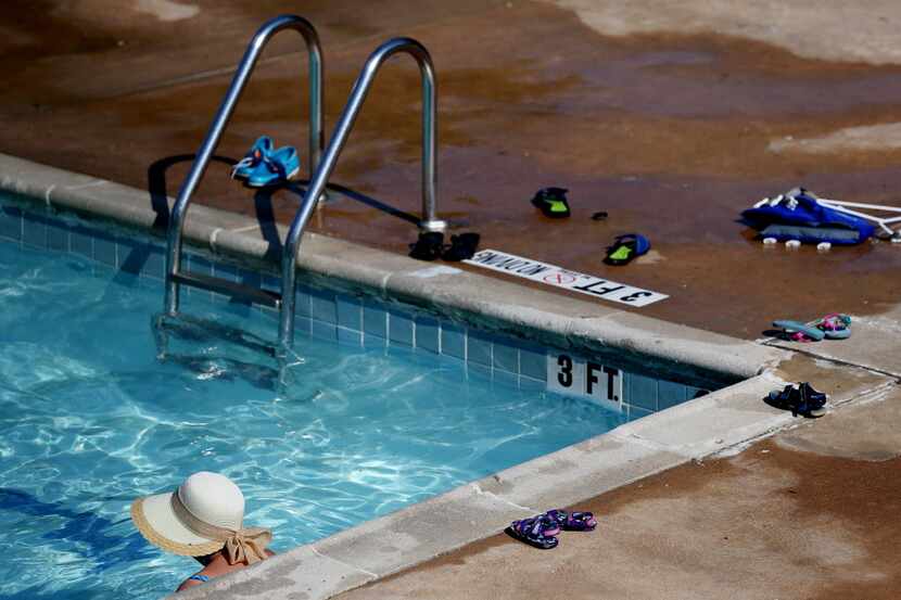 People swim at the Lake Highlands North Recreation Center swimming pool in Dallas. (File...
