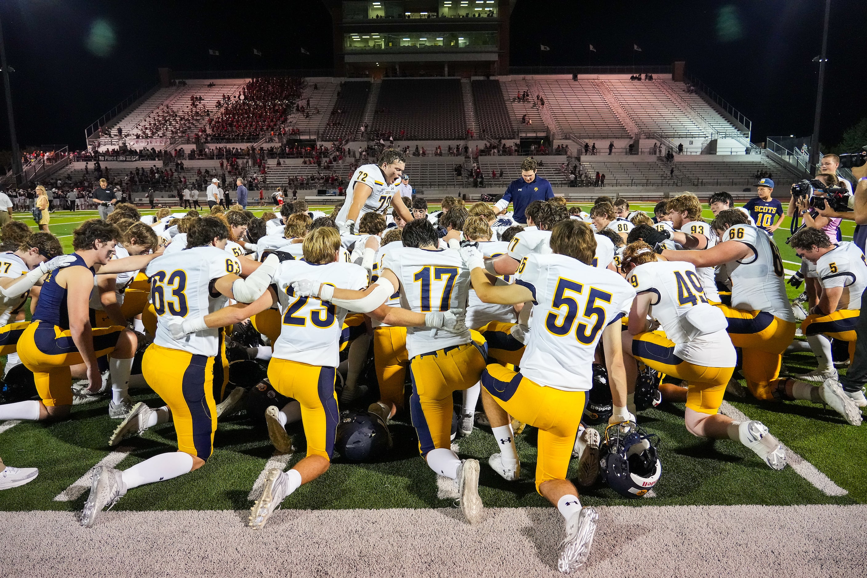 Highland Park offensive lineman Will Ogle (72) leads his teammates in prayer after a victory...