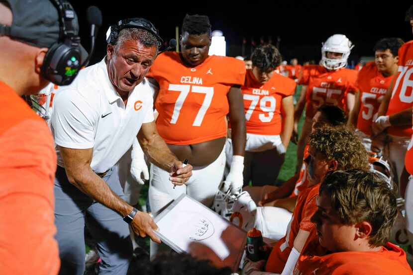 Celina head coach Bill Elliott instructs his team during the first half of a football game...