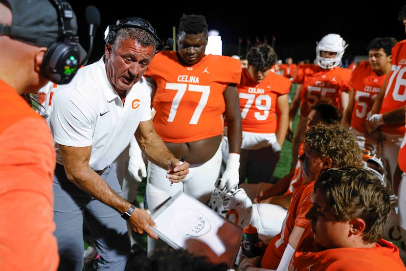 Celina head coach Bill Elliott instructs his team during the first half of a football game...