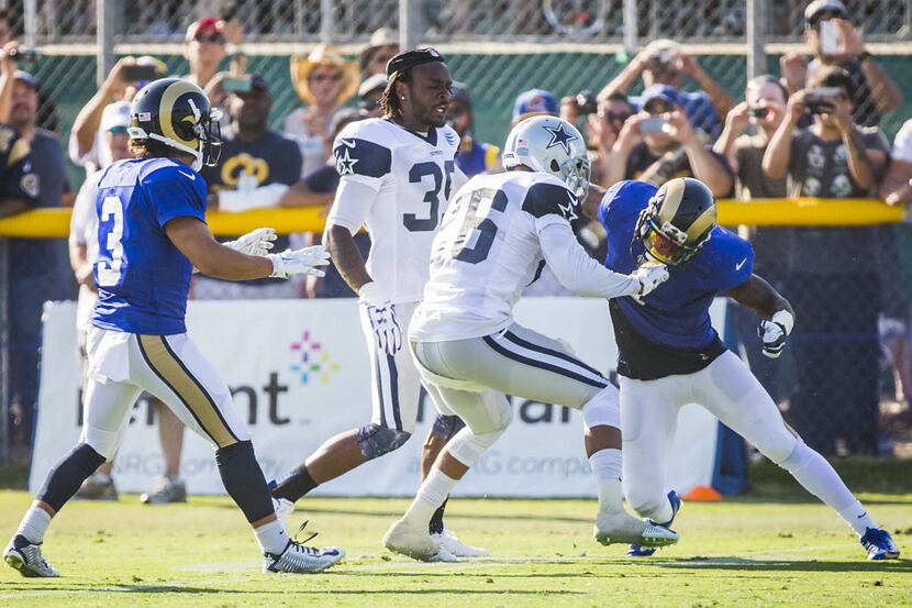 Dallas Cowboys defensive back Tyler Patmon (26) fights with St. Louis Rams wide receiver...