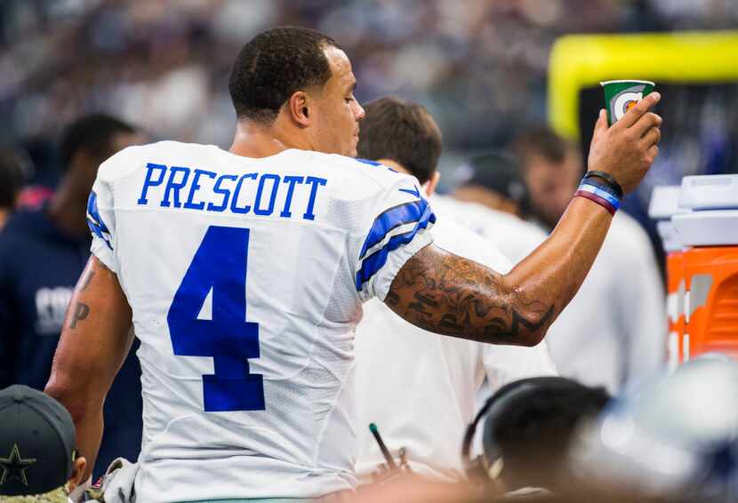 Dallas Cowboys quarterback Dak Prescott (4) throws away a Gatorade cup on the sideline...