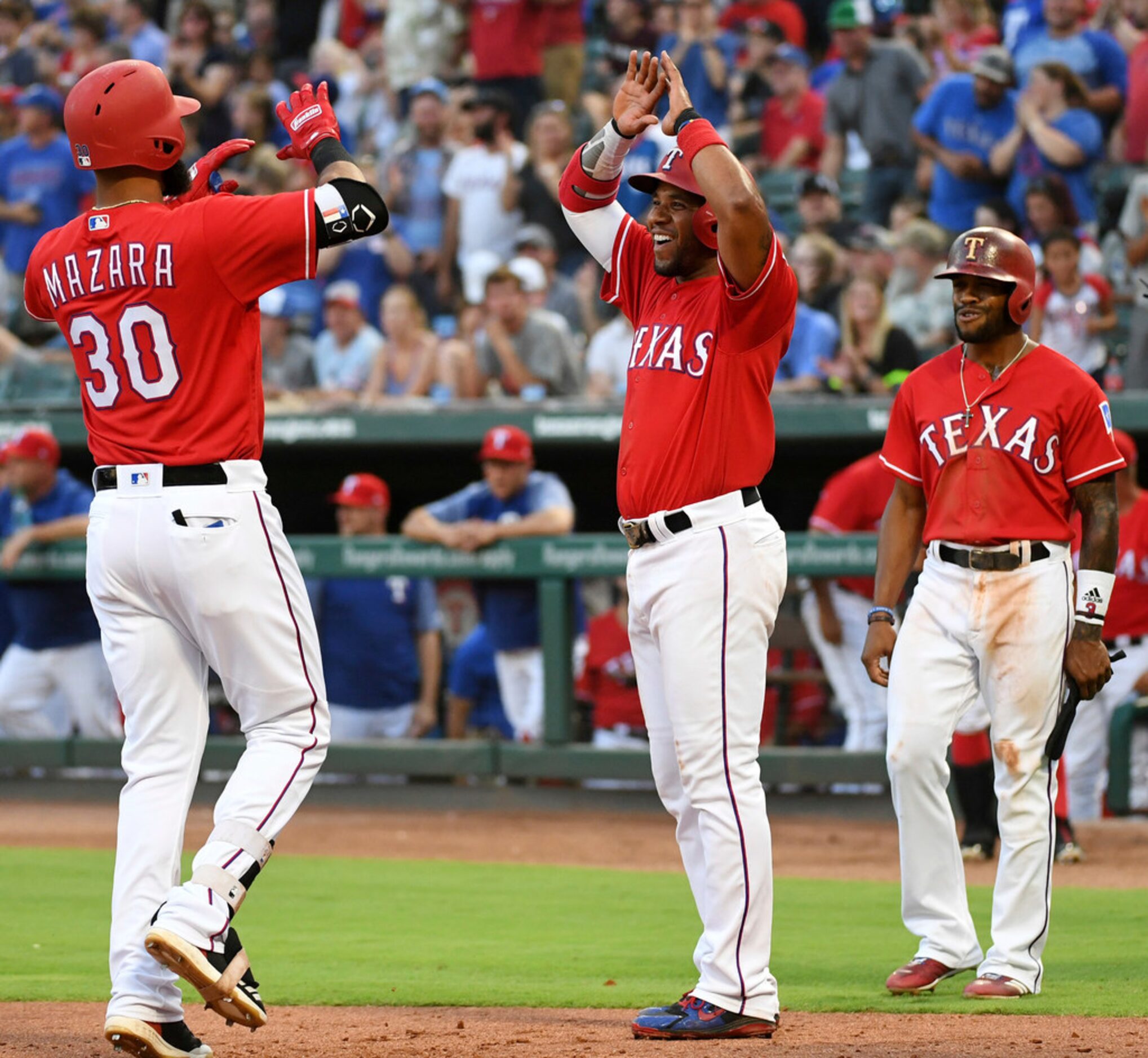 Texas Rangers' Elvis Andrus, center, and Delino DeShields, right, congratulate Nomar Mazara...