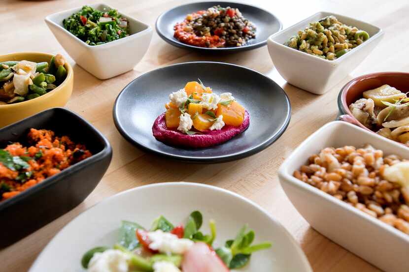 A wide array of mezes, marinated vegetables, including yellow beets on red beet hummus...