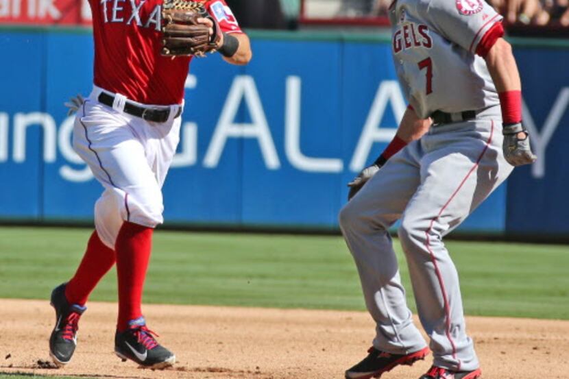Texas second baseman Ian Kinsler traps Angels'  base runner Andrew Romine between first and...