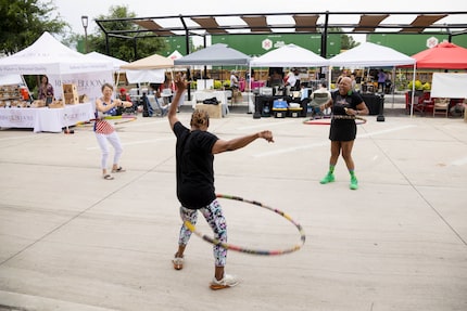 A train passes as Lisa Higgins, left, and Ronda Fitch, center, hula hoop with instructor...