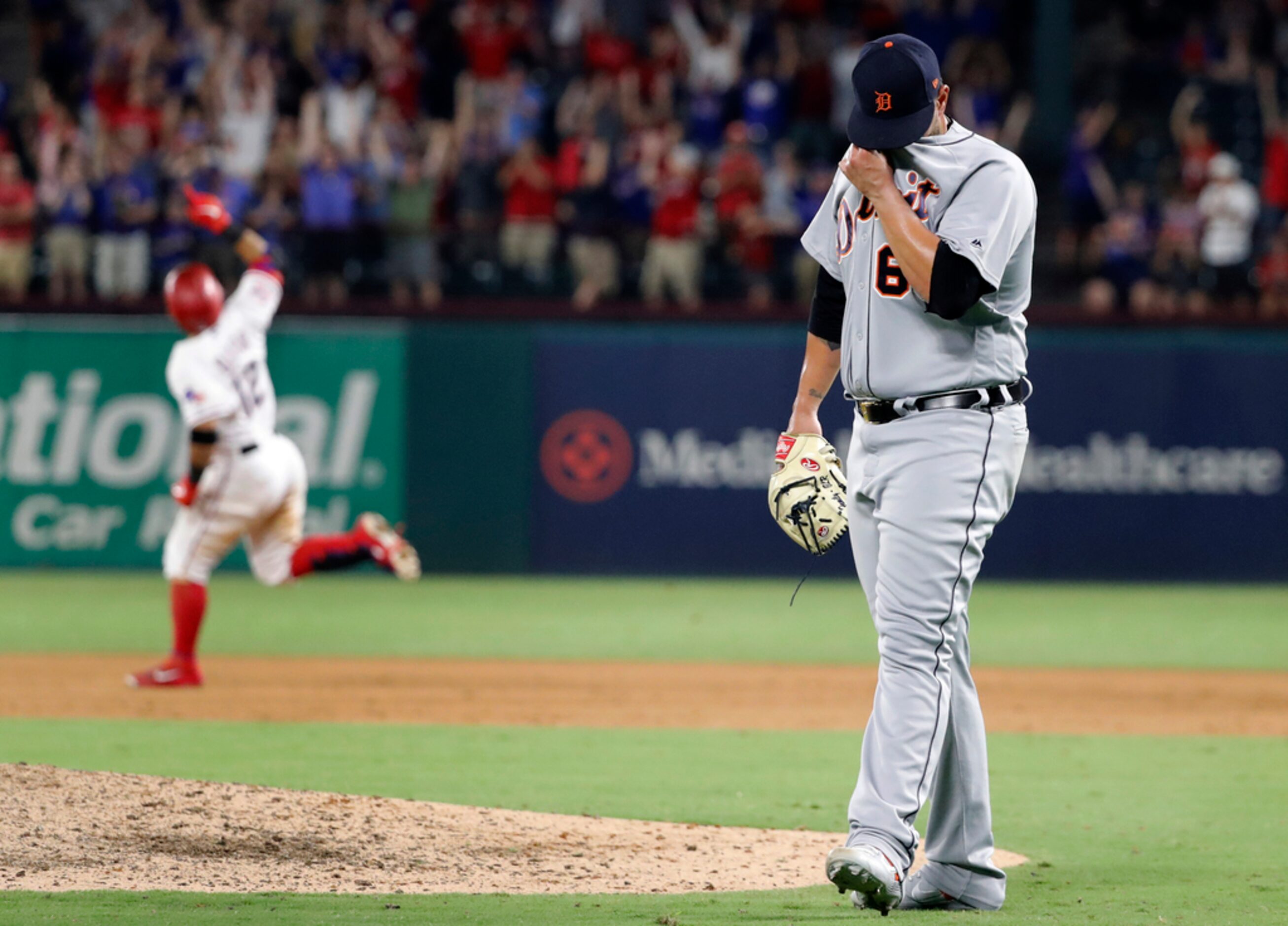 Detroit Tigers' Nick Ramirez wipes his face after giving up a solo home run to Texas...