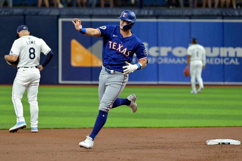 Josh Jung de los Rangers de Texas saluda al bullpen de su equipo al recorrer las bases tras...