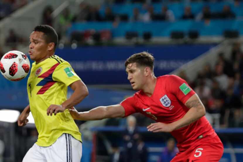 John Stones trata de sujetar a Carlos Bacca en el duelo entre Inglaterra y Colombia en...