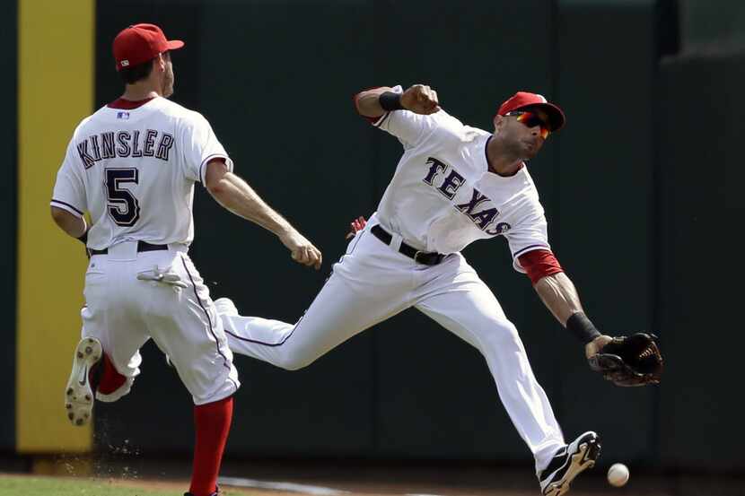 Texas Rangers' Ian Kinsler (5) watches as right fielder Alex Rios, right is unable to reach...