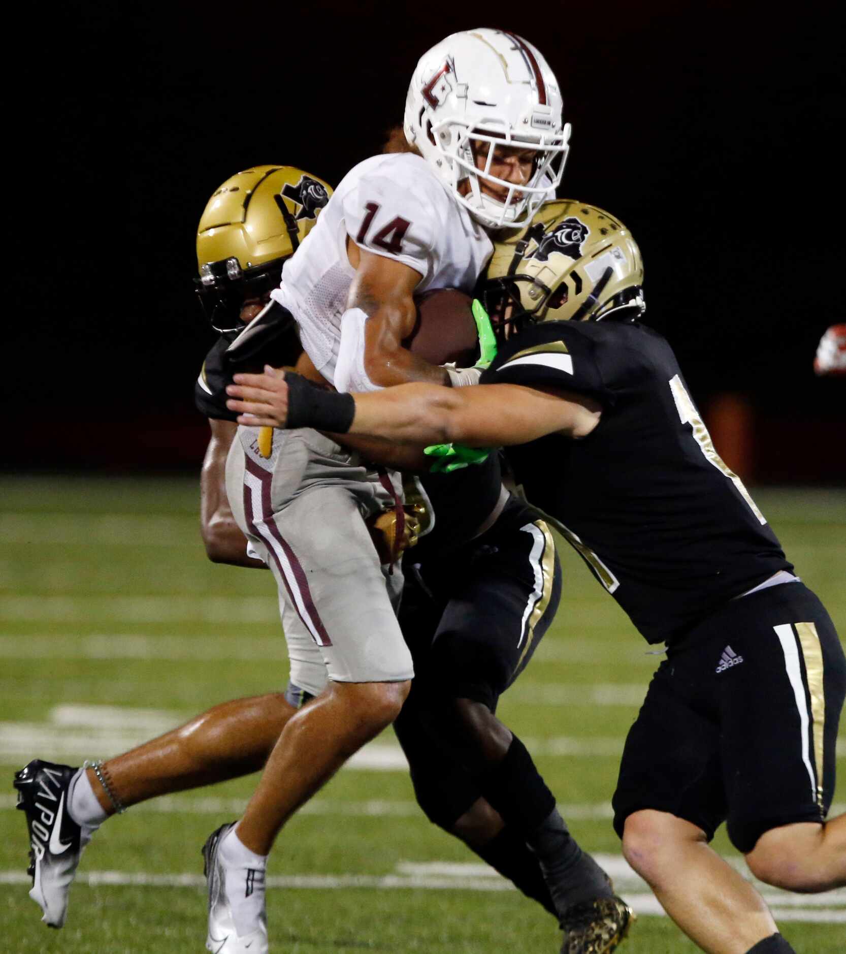 Lewisville WR Kye Stone (14) is hit by several Plano East defenders after making a catch...