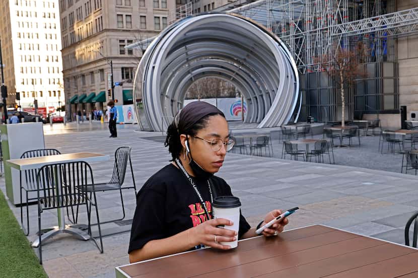 Caitlyn Jones, of Dallas, uses her phone at AT&T Discovery District in downtown Dallas,...