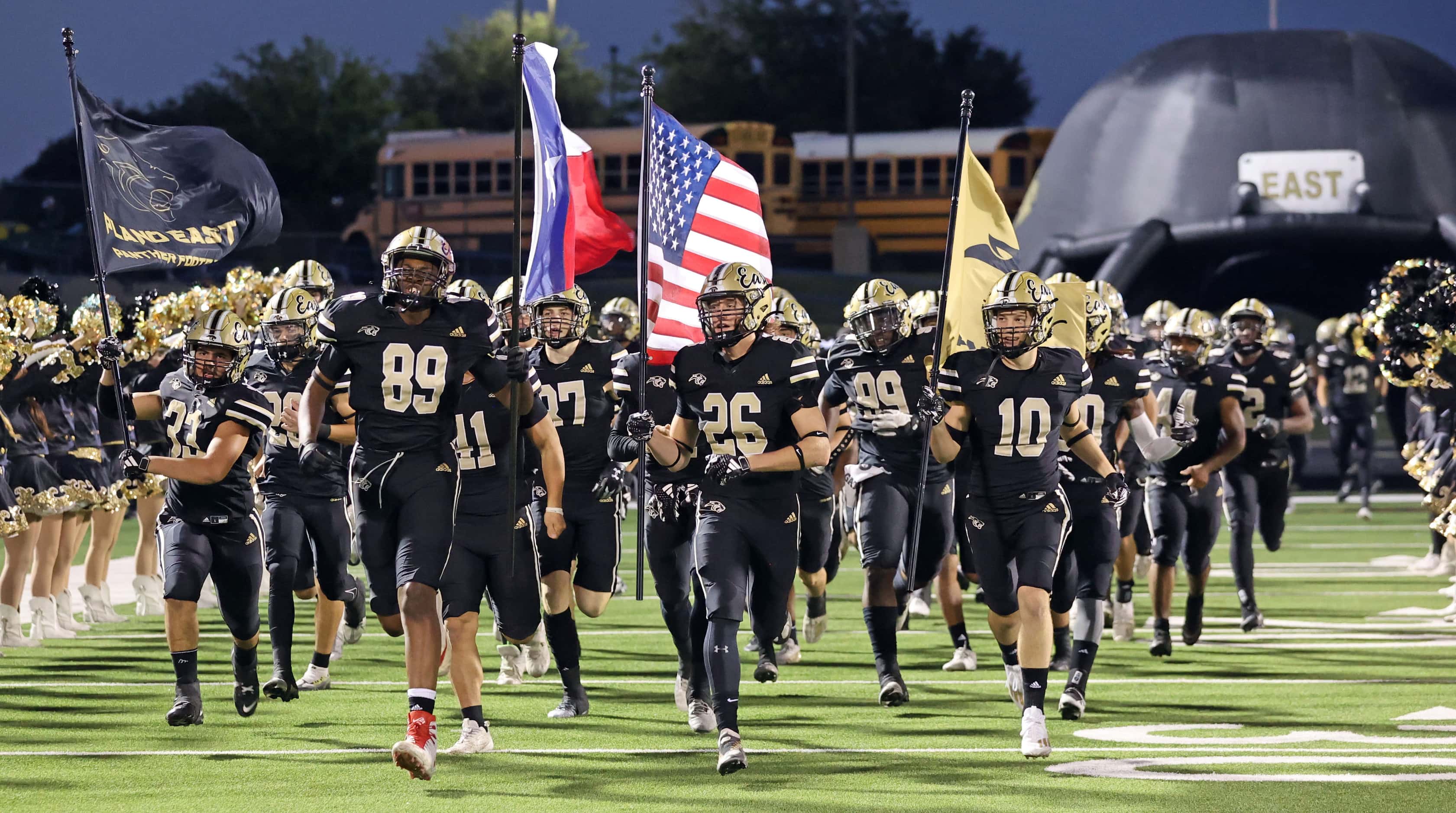 The Plano East high football team takes the field before the first half of a high school...