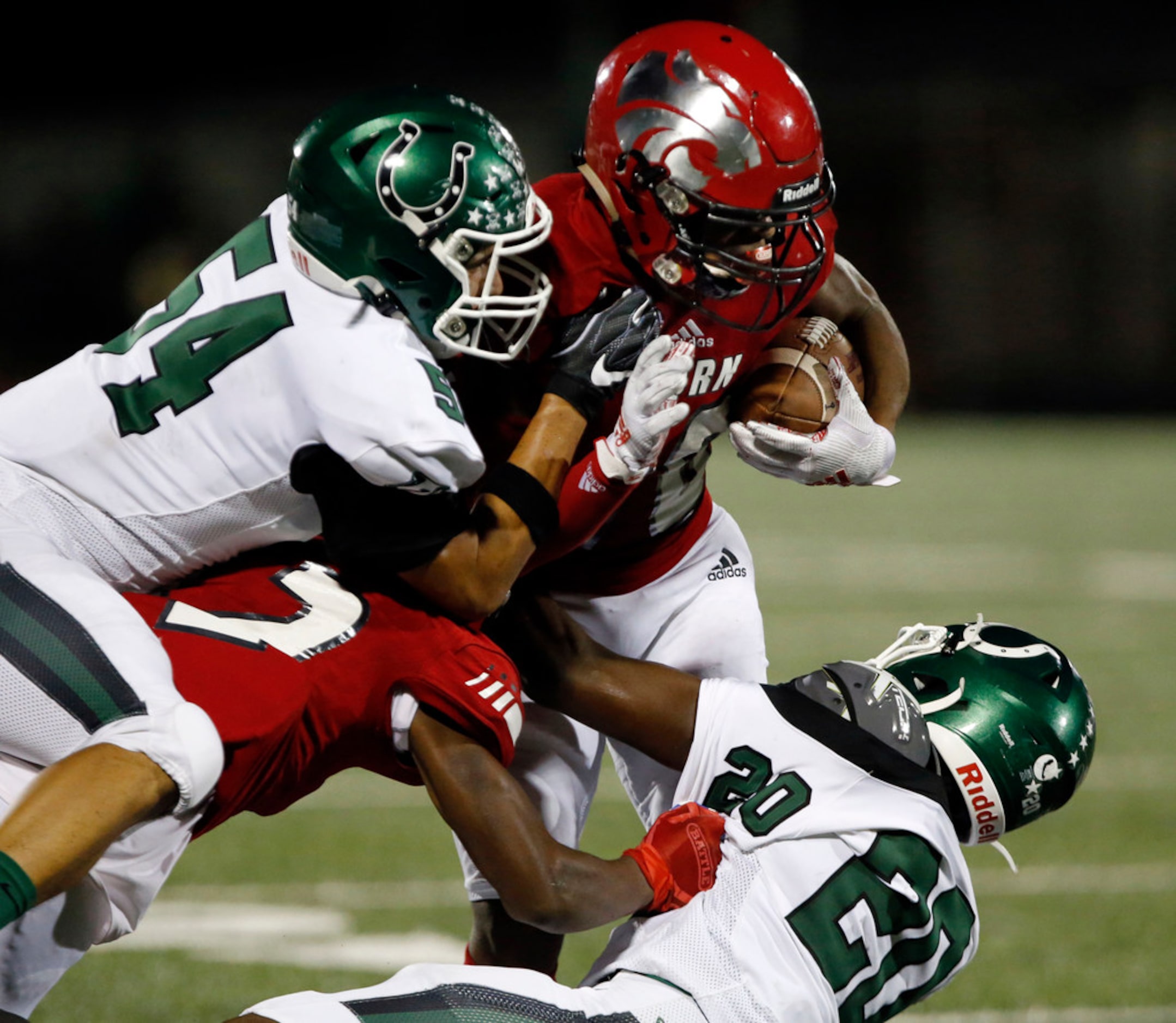 Mesquite Horn RB Ben Wyatt (10) is tackled by Arlington High defenders Antonio Franco (54)...