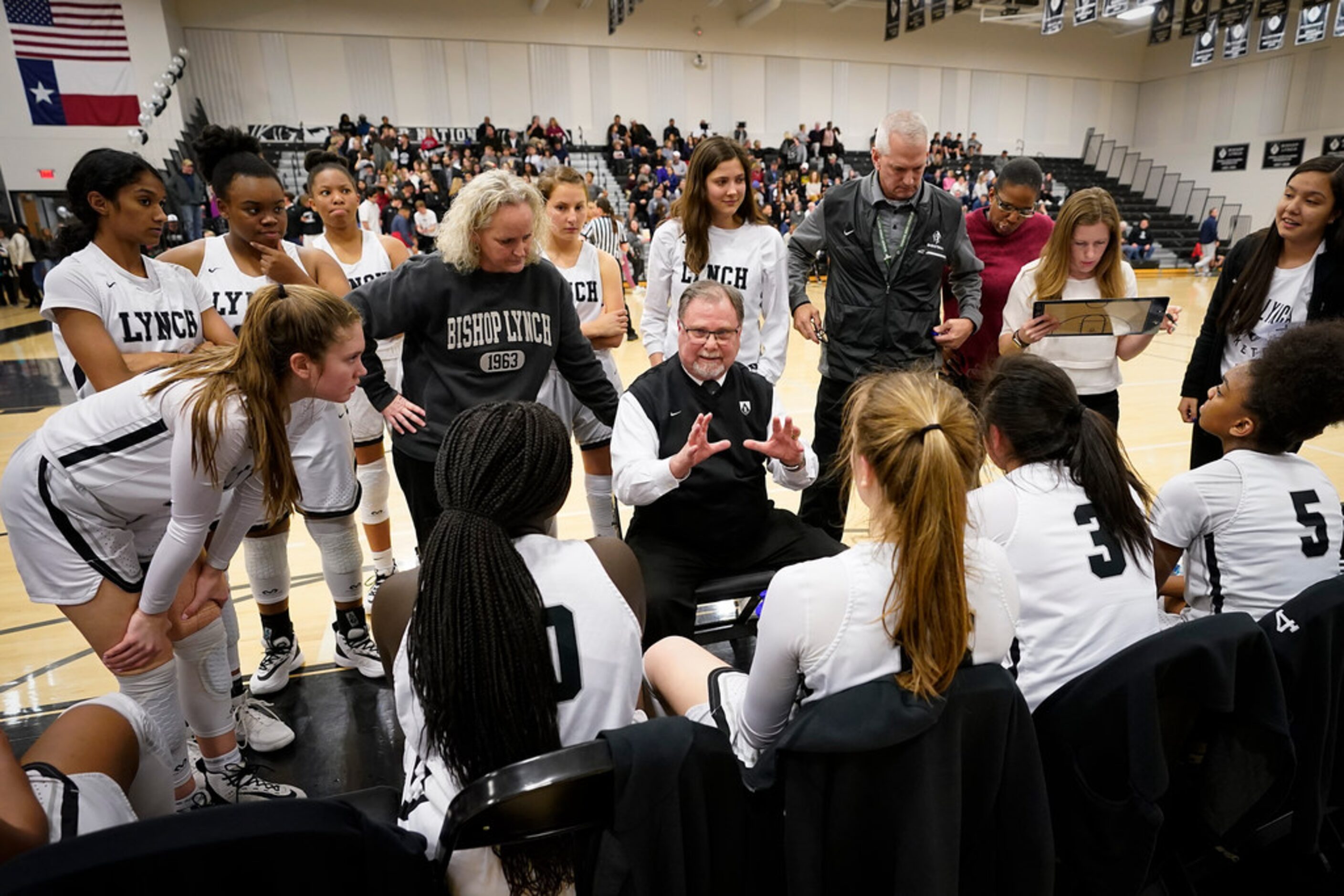 Bishop Lynch players huddle around head coach Andy Zihlman during a time out in a TAPPS 2-6A...