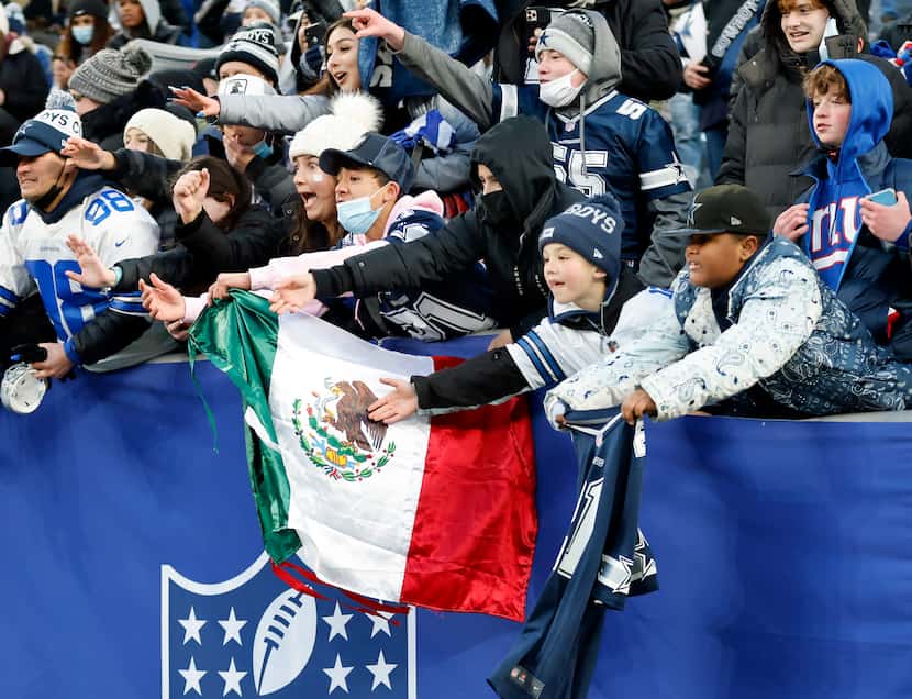 A Dallas Cowboys fan waves the Mexico flag as they celebrate the team's win over the New...