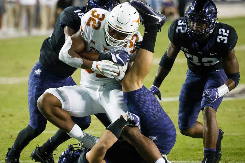 Texas running back Daniel Young (32) is brought down by TCU defensive end Michael Epley...