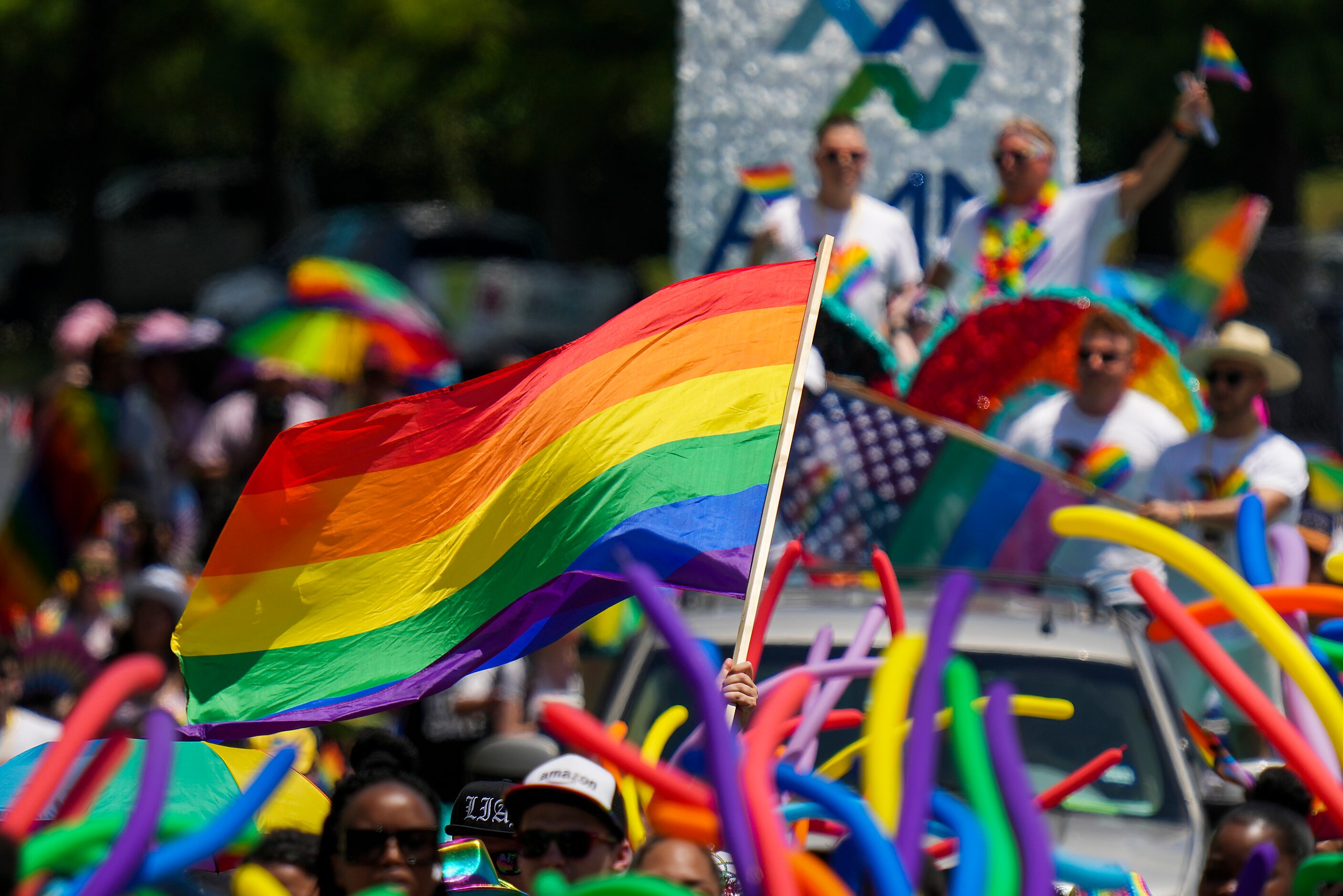 A participant waves a rainbow flag during the annual Alan Ross Texas Freedom Parade...