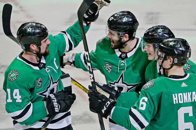Dallas Stars left wing Jamie Benn (14) is congratulated by teammates after Benn scored on...