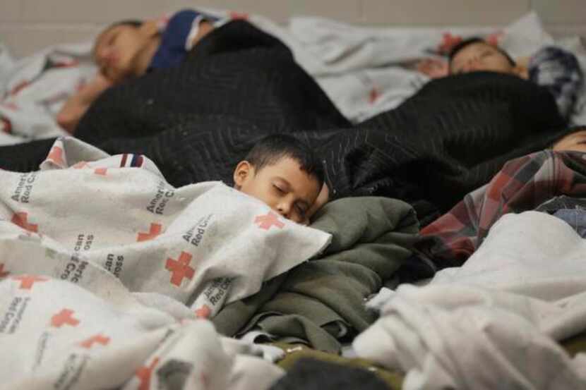 FILE - This June 18, 2014, file photo shows children detainees sleeping in a holding cell at...