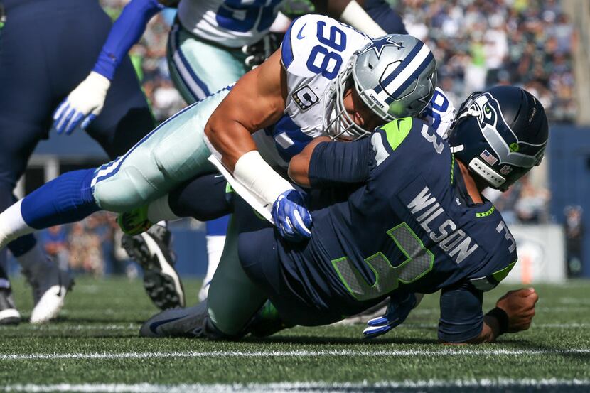 Dallas Cowboys defensive end Tyrone Crawford (98) hits Seattle Seahawks quarterback Russell...