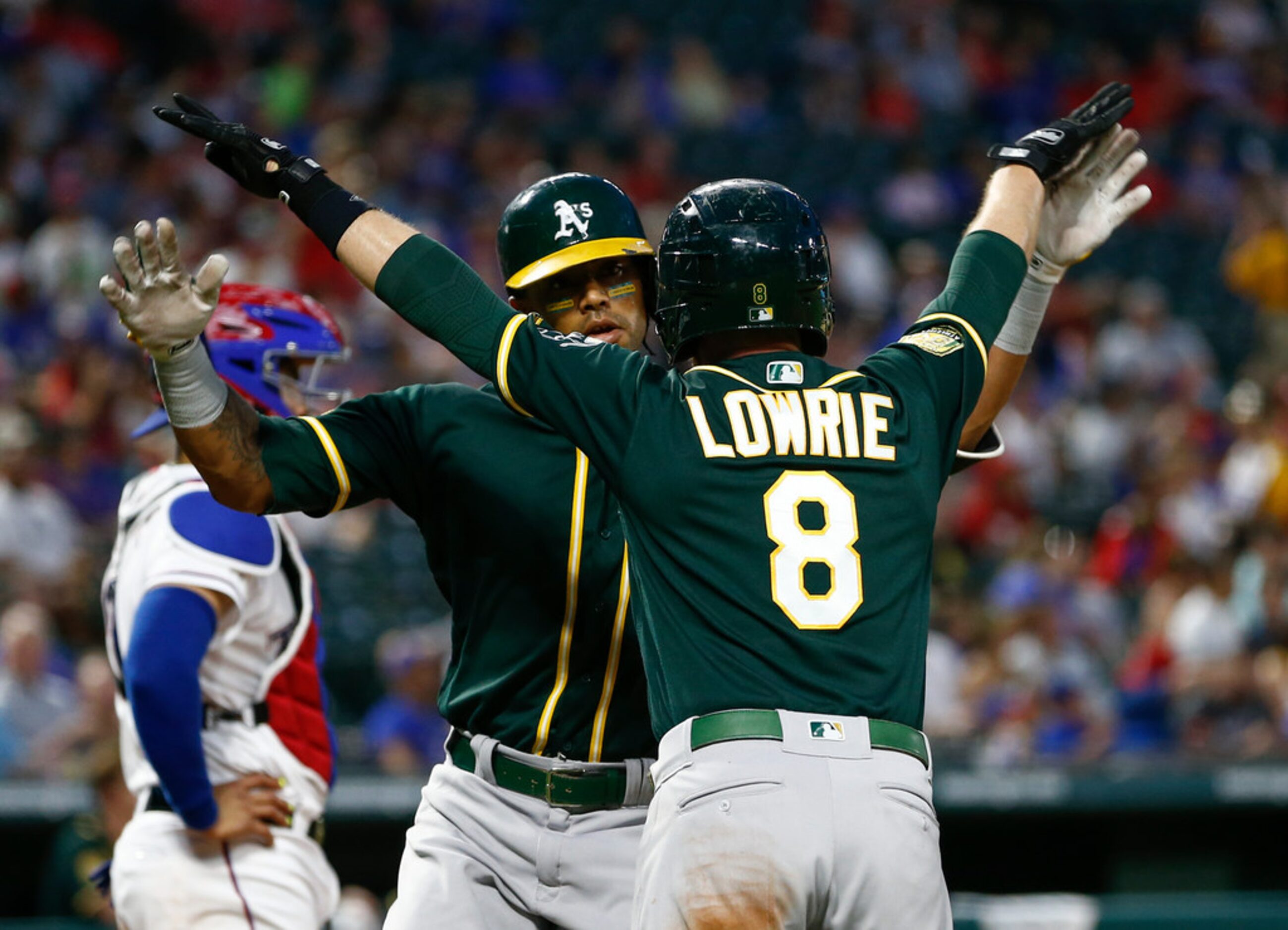 Oakland Athletics' Jed Lowrie (8) congratulates Khris Davis on his two-run home run against...