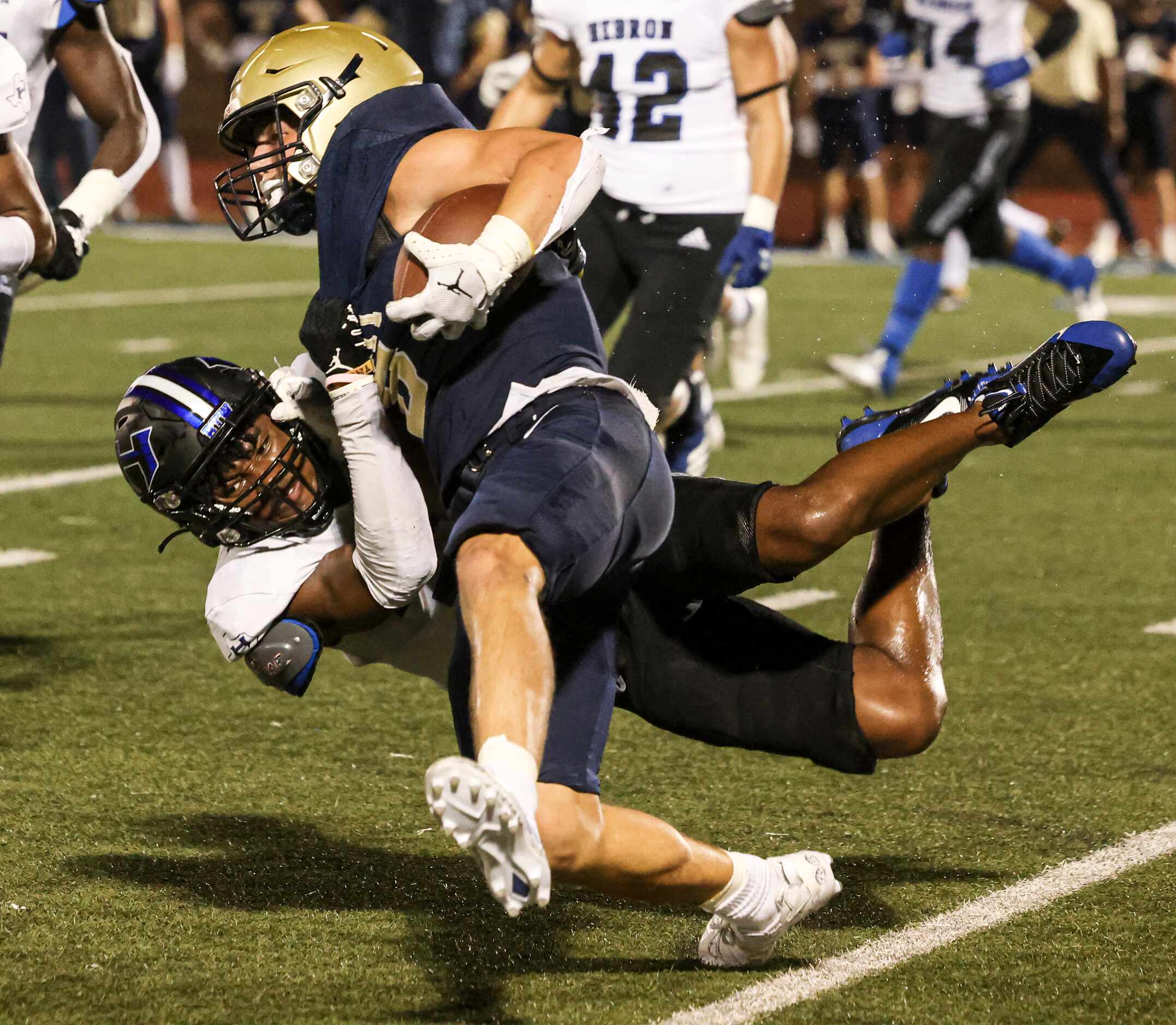 Hebron High School Dylan Goodrich (7) takes down Jesuit Dallas Reed Pfaffenberger (8) at the...