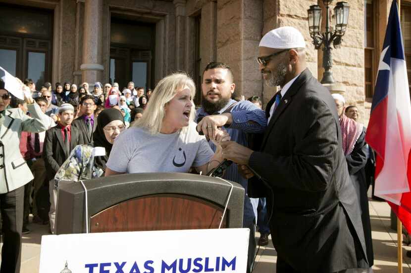 Protester Christine Weick wrestles away the microphone during the Texas Muslim Capitol Day...