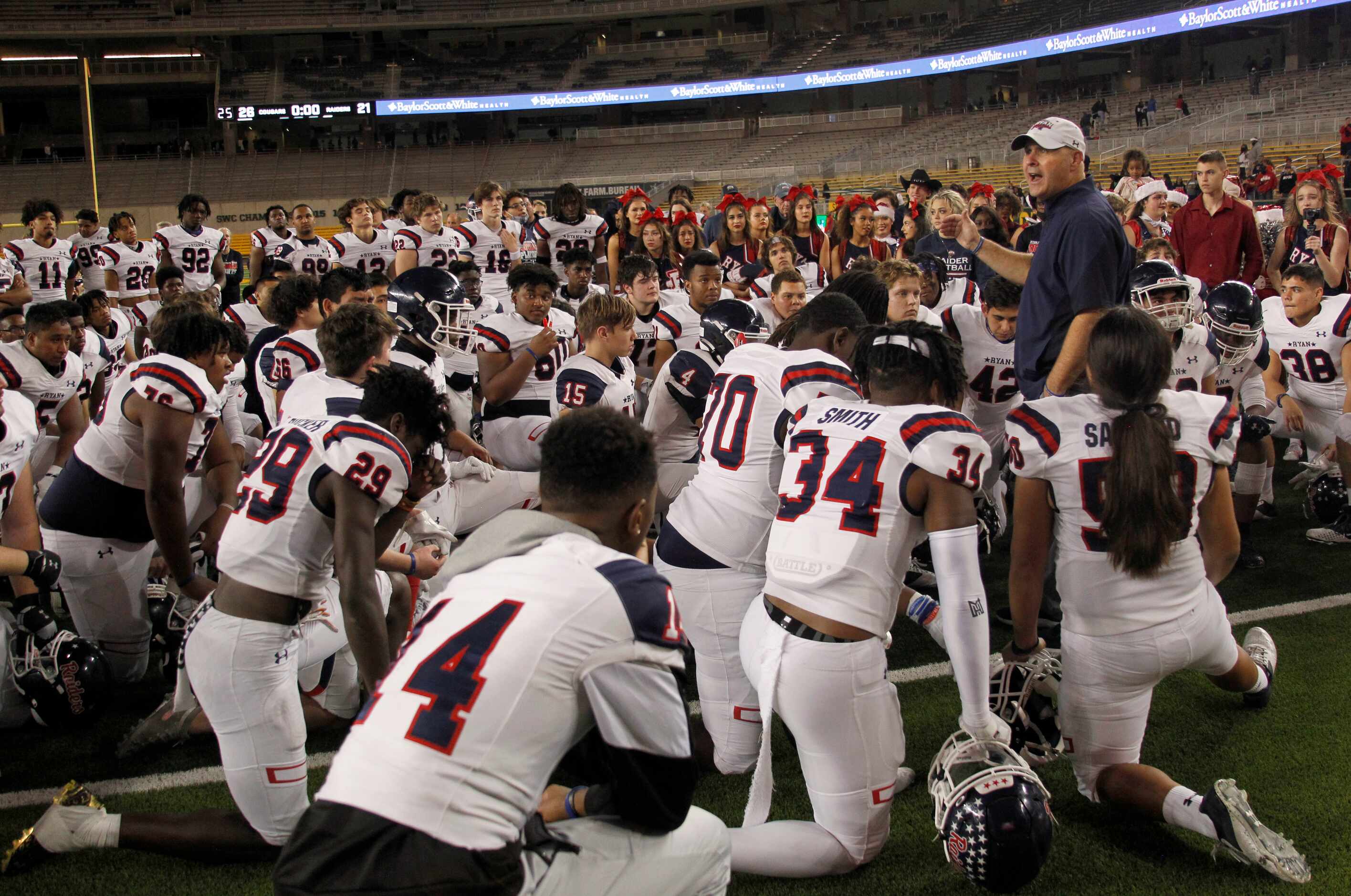 Denton Ryan head coach Dave Henigan shares an inspirational post-game message with his...