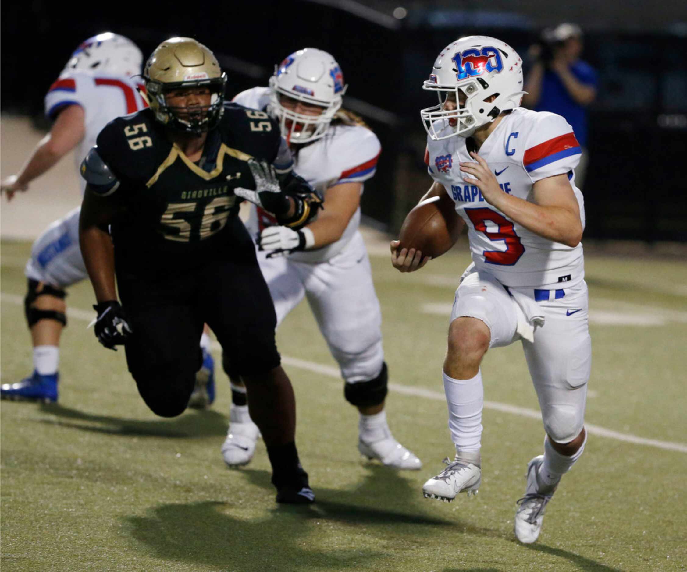 Grapevine quarterback Austin Alexander (9) tries to get past Birdvilles' Marcus Duckworth...